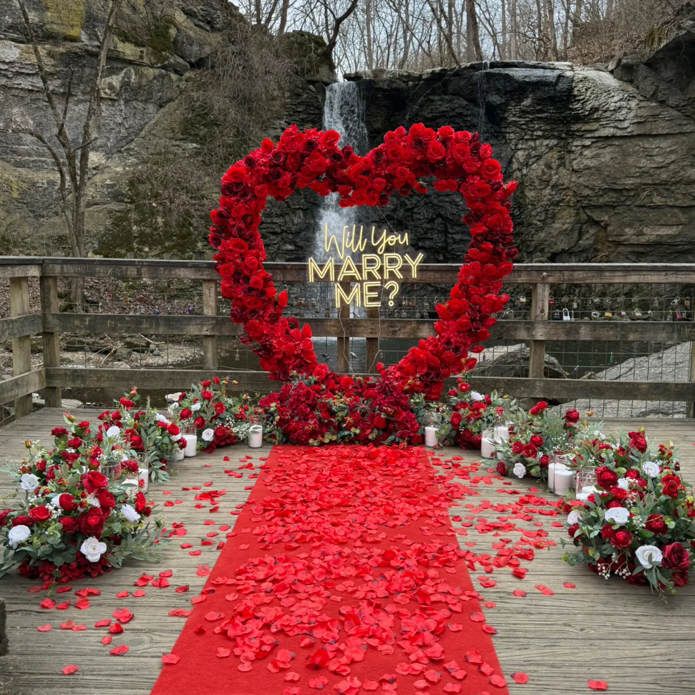 Red rose heart arch and petal aisle proposal decor